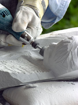 marble sculptor using a handheld grinder