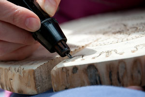 carver using a wood burning tool